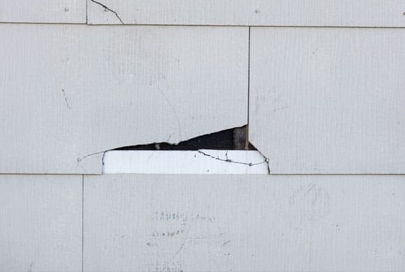 Cracked asbestos cladding on the outside of a house